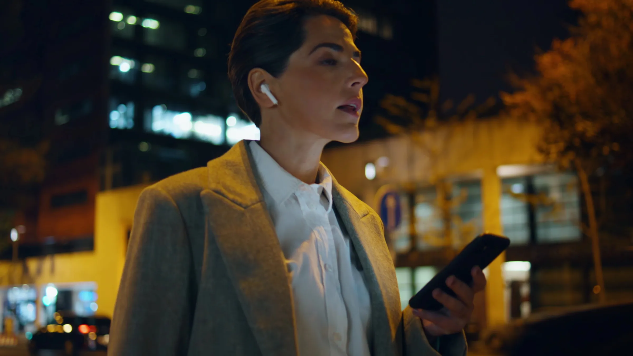 Una donna ascolta con gli auricolari la sera in città